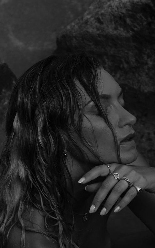 Woman wearing rings in a moody black-and-white shot.