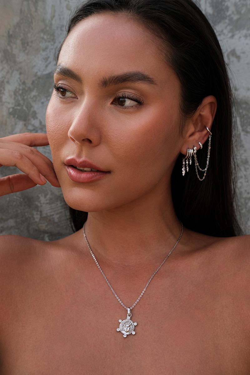 Model wearing Silver layered ear cuff set with chains and a silver chain with pendant.