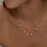 Close-up of gold Palma necklace with diamond-shaped charms on a woman.