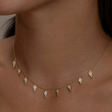 Gold Palma necklace with diamond-shaped charms on a woman.
