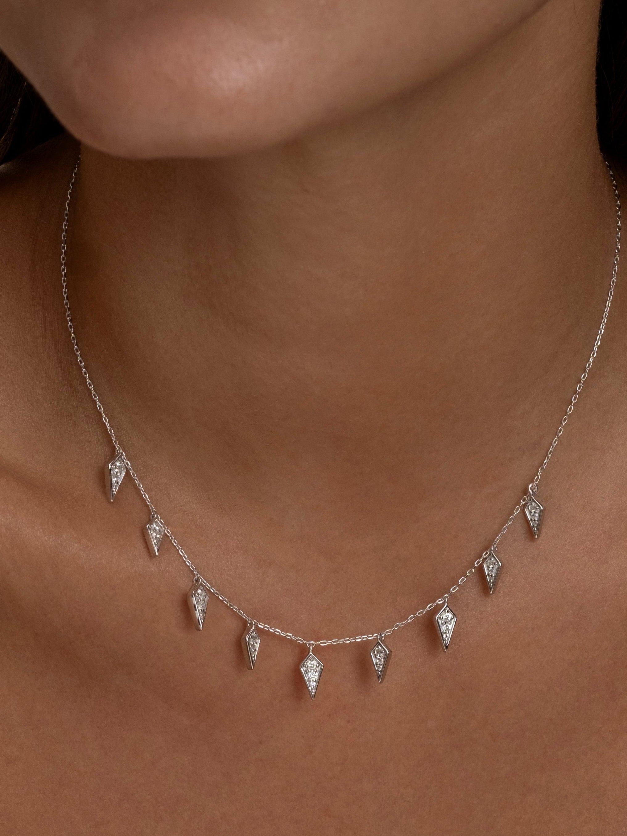Silver Palma necklace with diamond-shaped charms on a woman.