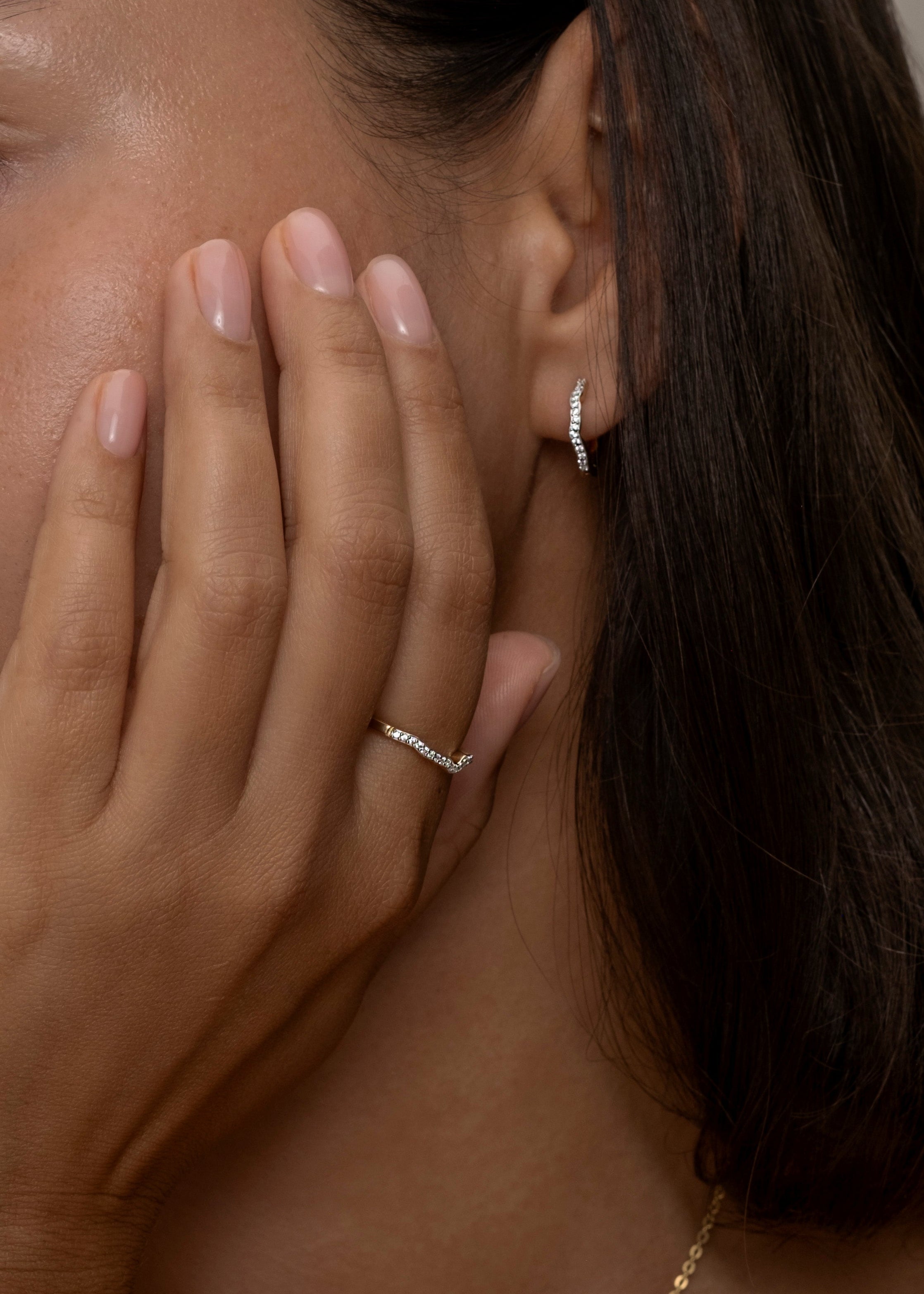 Elegant gold Riviera ring on hand with matching earring