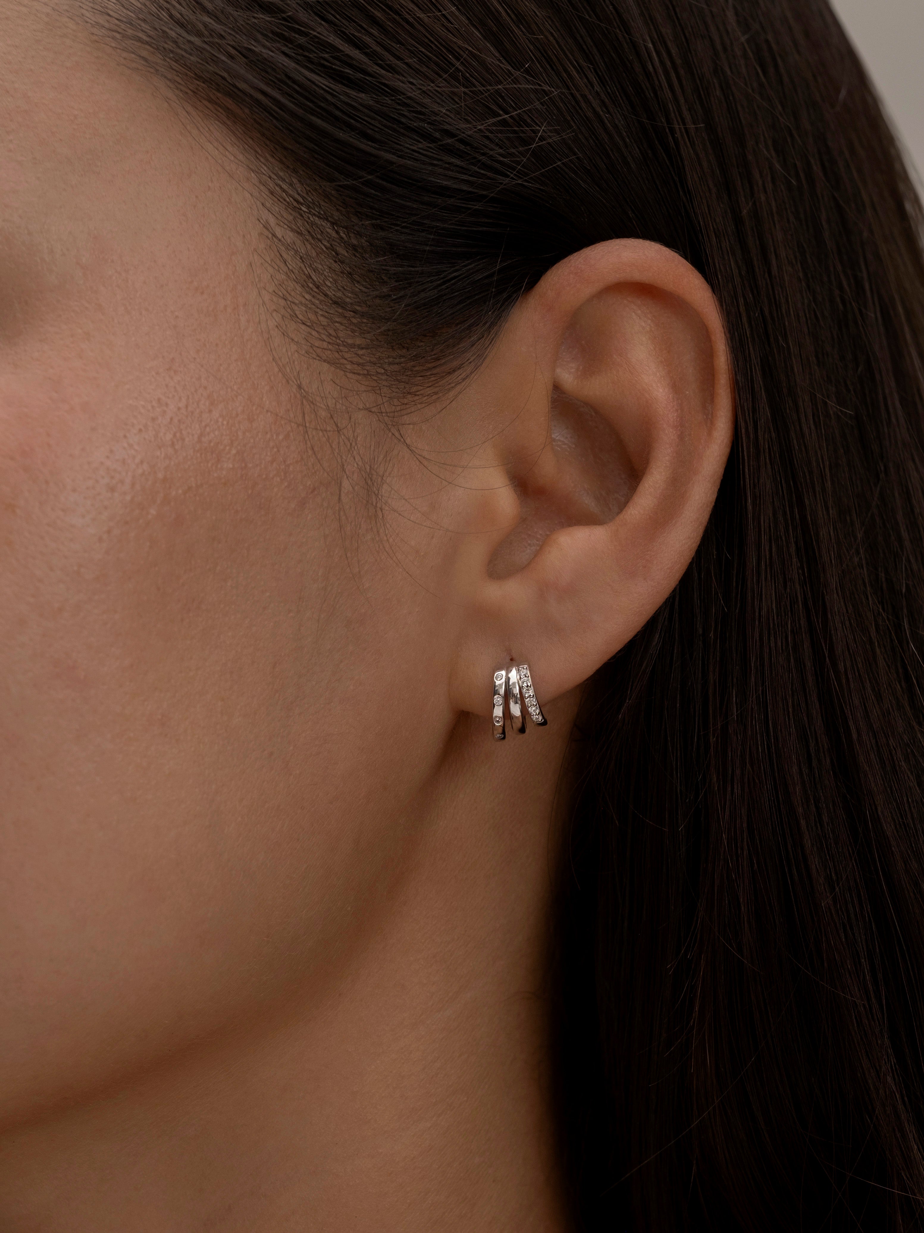 Minimalist silver triple-hoop earrings on ear