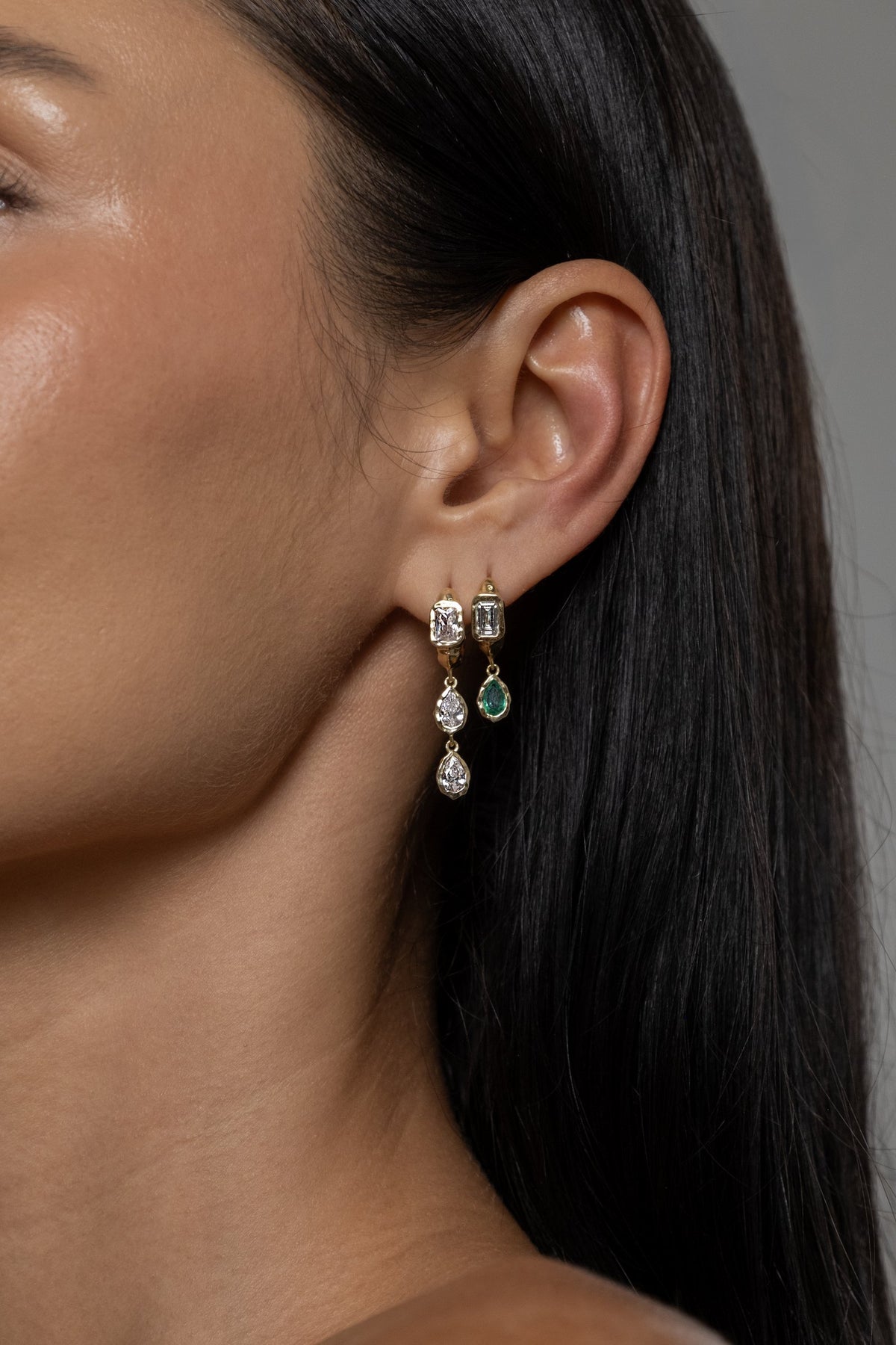 Model wearing Brooklyn Earrings (moissanite), Brooke Earrings (lab emerald)