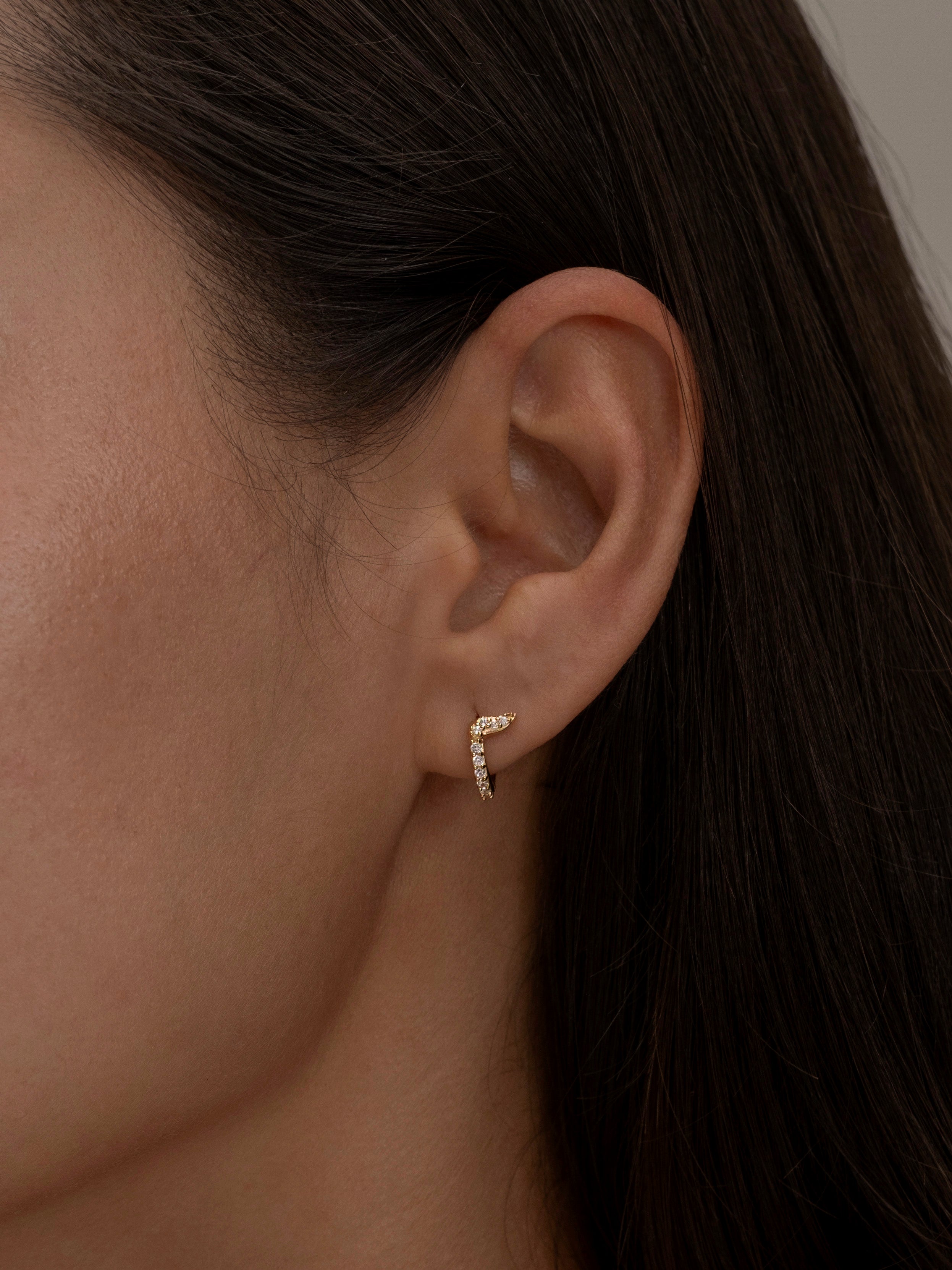 Minimalist gold halo hoop earring with diamond details.