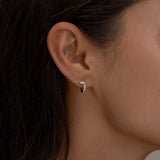 Minimalist silver hoop earring with diamond details.