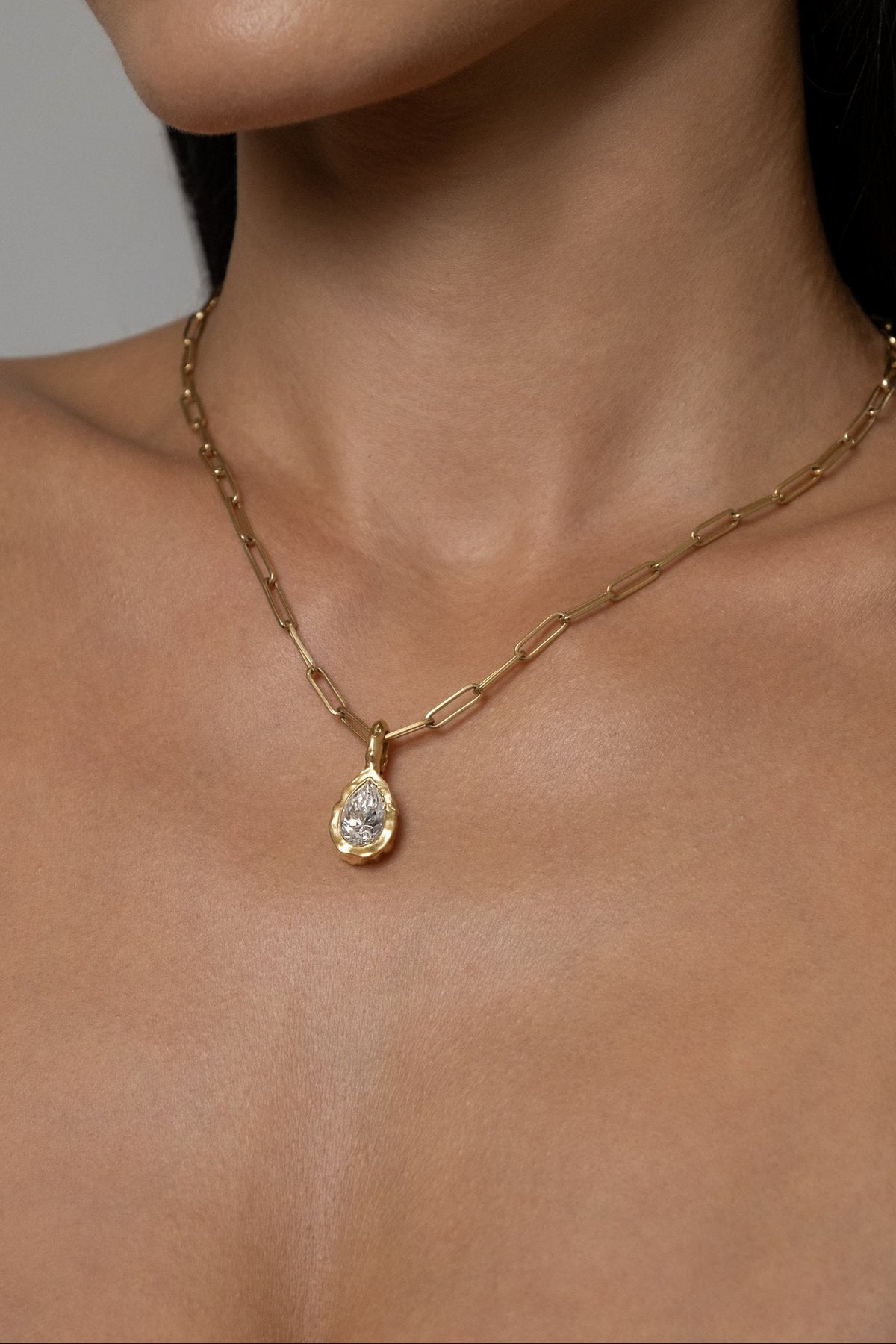 Model wearing Molten Pear Pendant (moissanite), Paperlink Chain
