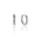 Pair of textured silver huggie hoop earrings on display.