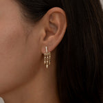 Close-up of woman's ear with gold dangling earrings 5