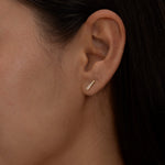 Gold Chloe stud earring on a woman's ear.