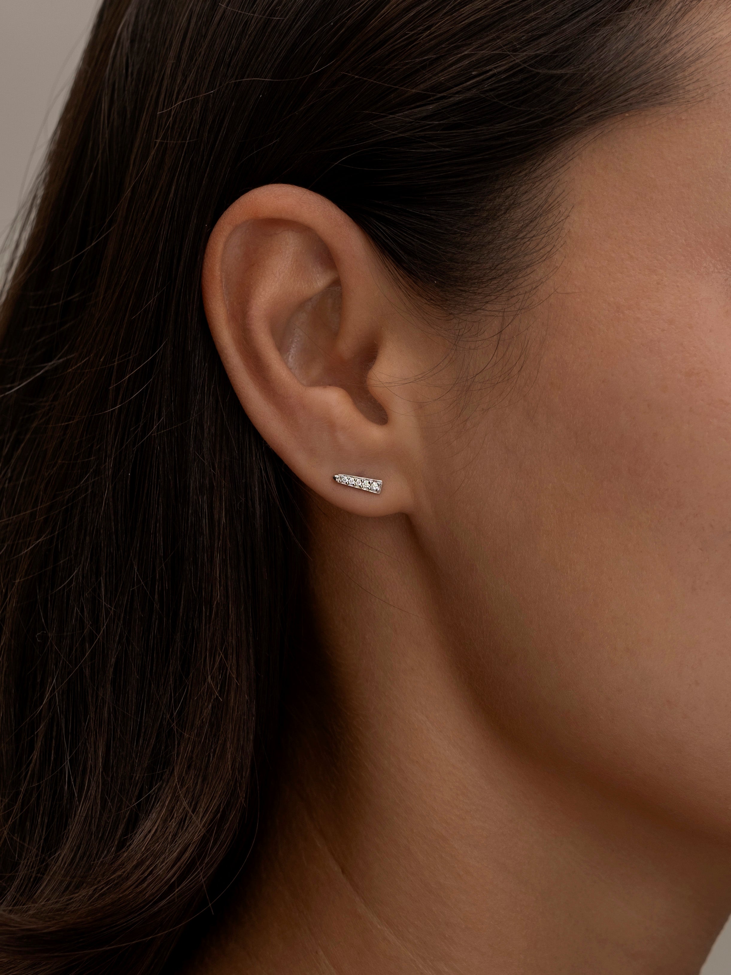 Silver Chloe stud earring on a woman's ear.