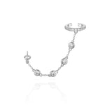 A silver ear cuff linked to a stud by a gemstone chain.
