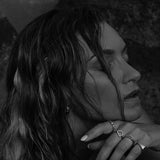 Woman wearing rings in a moody black-and-white shot.