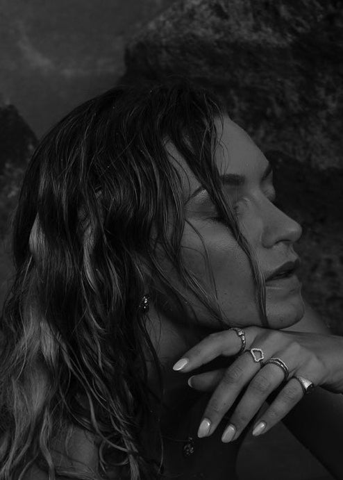 Woman wearing rings in a moody black-and-white shot.