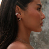 Portrait of a woman wearing diamond silver earrings and a silver necklace.
