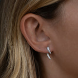 Close-up of ear with silver double stud earrings.