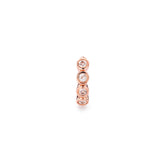Close up of rose gold Milano hoop earring with bezel-set gemstones.