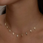 Gold Palma necklace with diamond-shaped charms on a woman.
