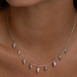 Silver Palma necklace with diamond-shaped charms on a woman.