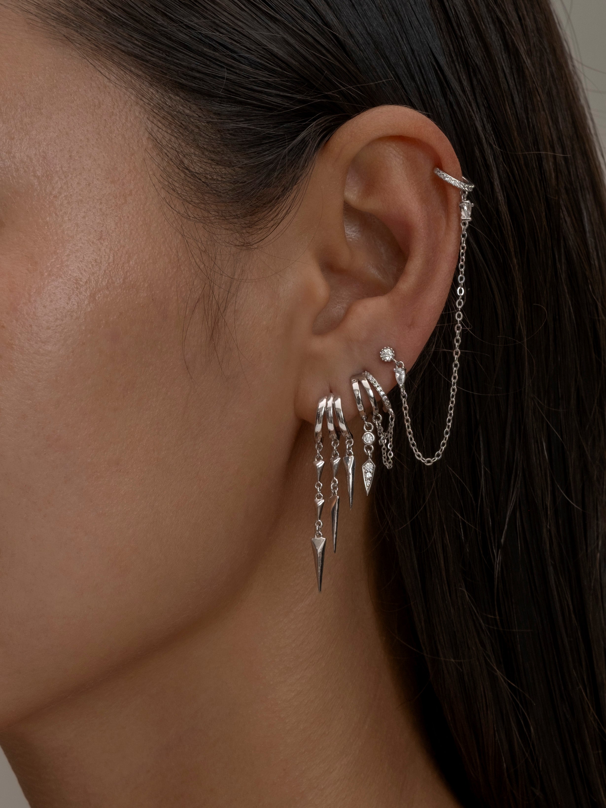 Paloma Silver ear cuff with chain and spike earrings close-up.