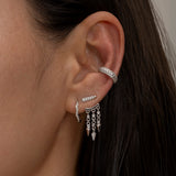 Silver ear cuff and dangling earrings on woman's ear 1