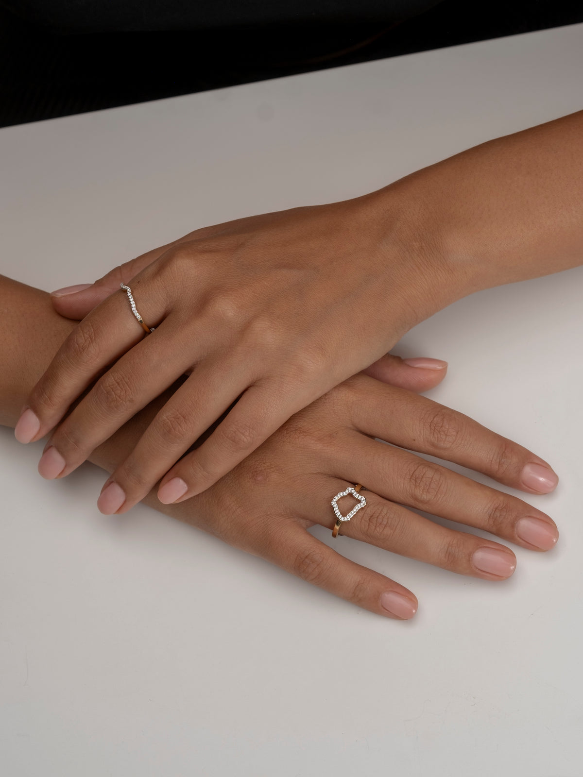 Hands adorned with delicate gold and diamond rings