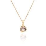 Close up of Sahara Mini gold necklace with a round gemstone pendant.