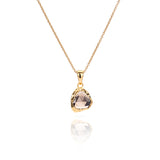 Close up of Sahara Mini gold necklace with a round gemstone pendant.