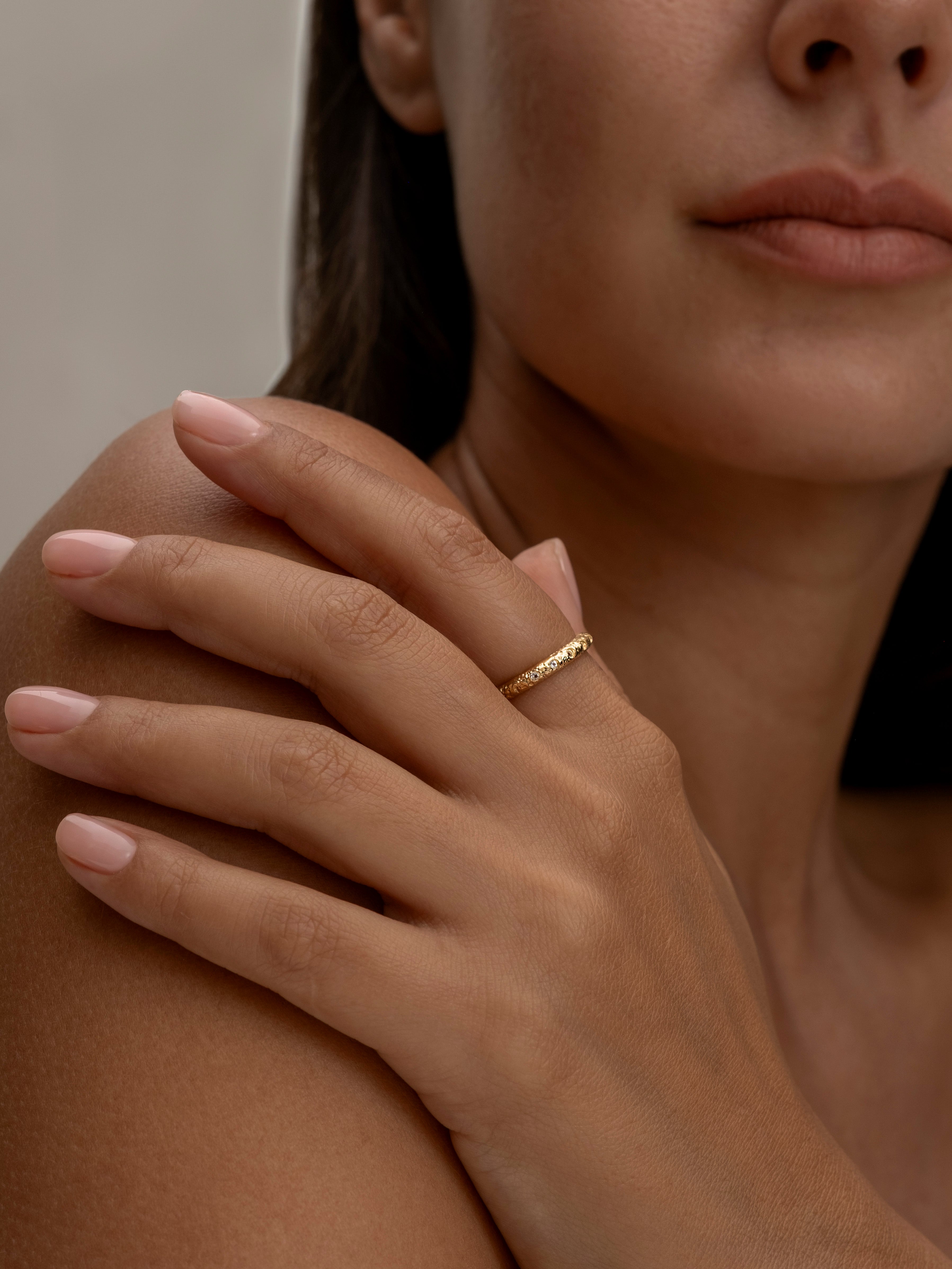 Close-up of a woman's hand with a delicate gold ring.