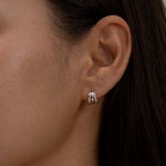 Minimalist silver triple-hoop earrings on ear