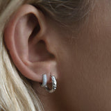 Woman with athena silver hoop earrings.
