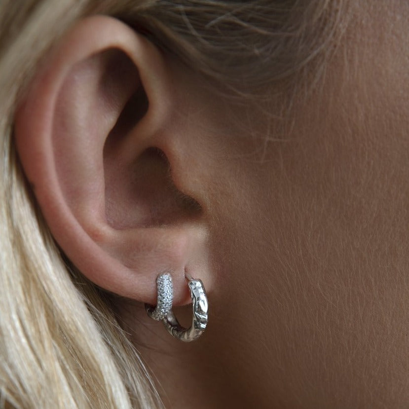 Woman with athena silver hoop earrings.