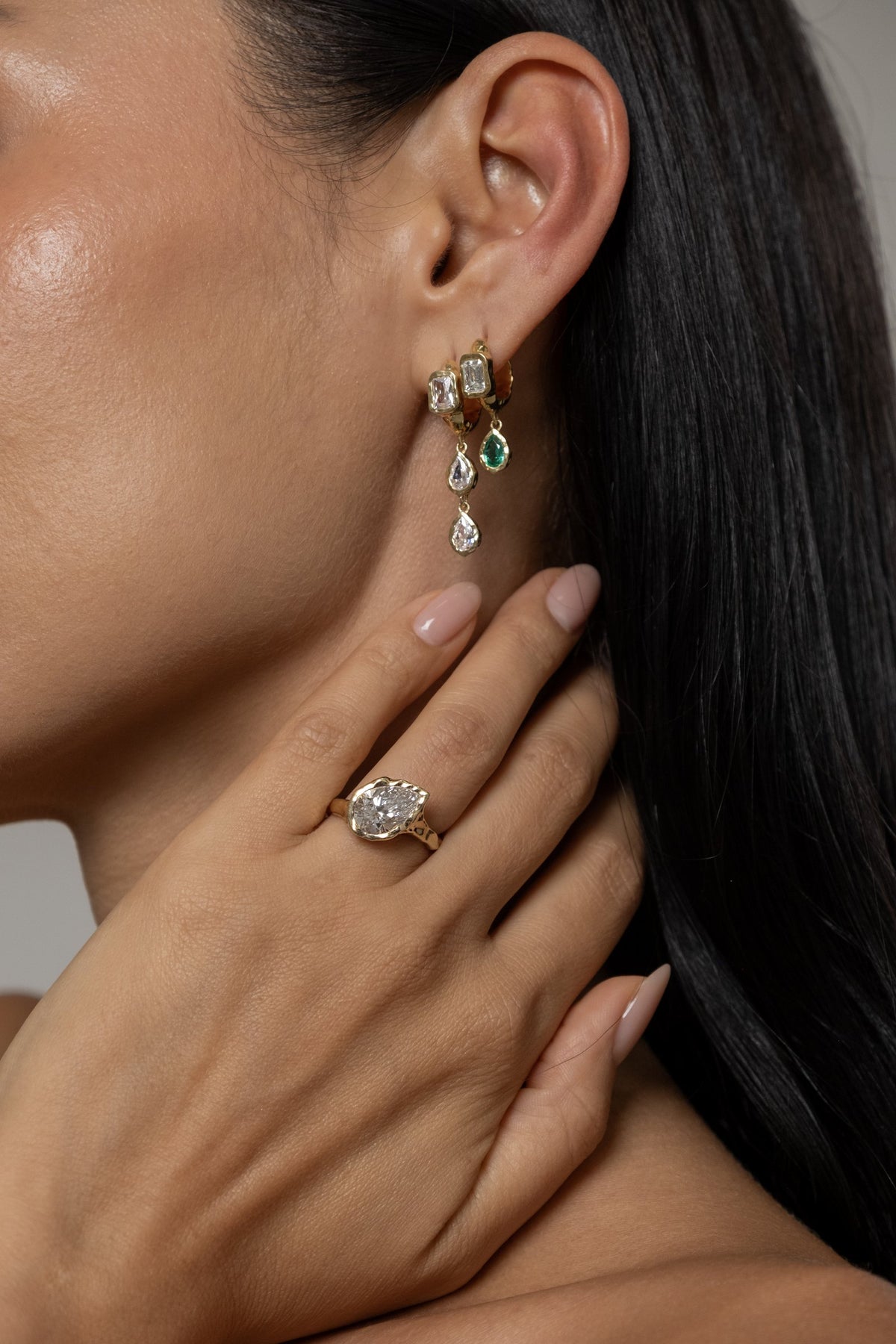 Model wearing Brooklyn Earrings (moissanite), Brooke Earrings (lab emerald), Molten Pear Ring (moissanite)