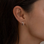 Minimalist silver hoop earring with diamond details.
