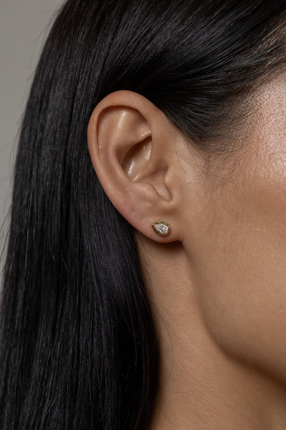 Model wearing Molten Pear Studs (moissanite)
