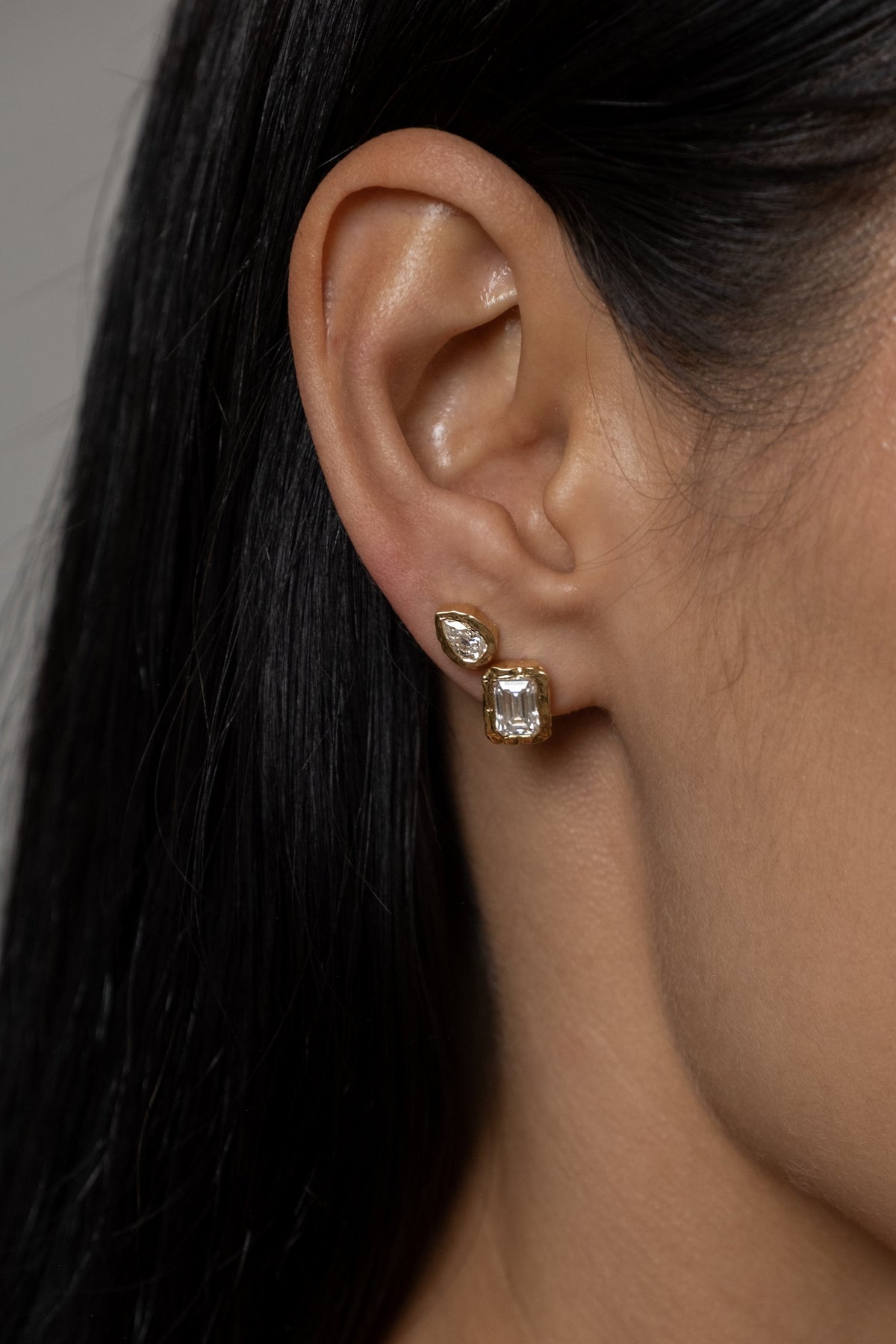 Model wearing Molten Pear Studs (moissanite), Molten Square Studs (moissanite)
